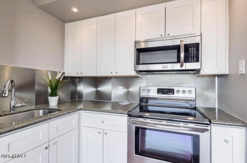 4750 North Central Avenue, Unit L8 Phoenix, AZ 85012 - Photo 10 of 55 a kitchen with stainless steel appliances granite countertop grey cabinets a stove a sink and dishwasher