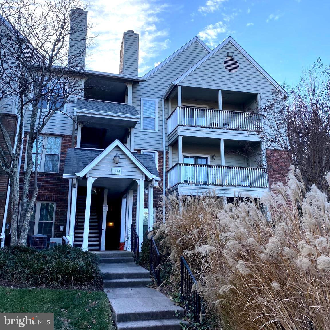 a front view of a house with plants and entryway