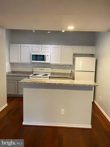 a view of kitchen with stainless steel appliances wooden floor