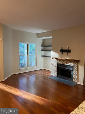 a living room with hard wood floors and a fireplace