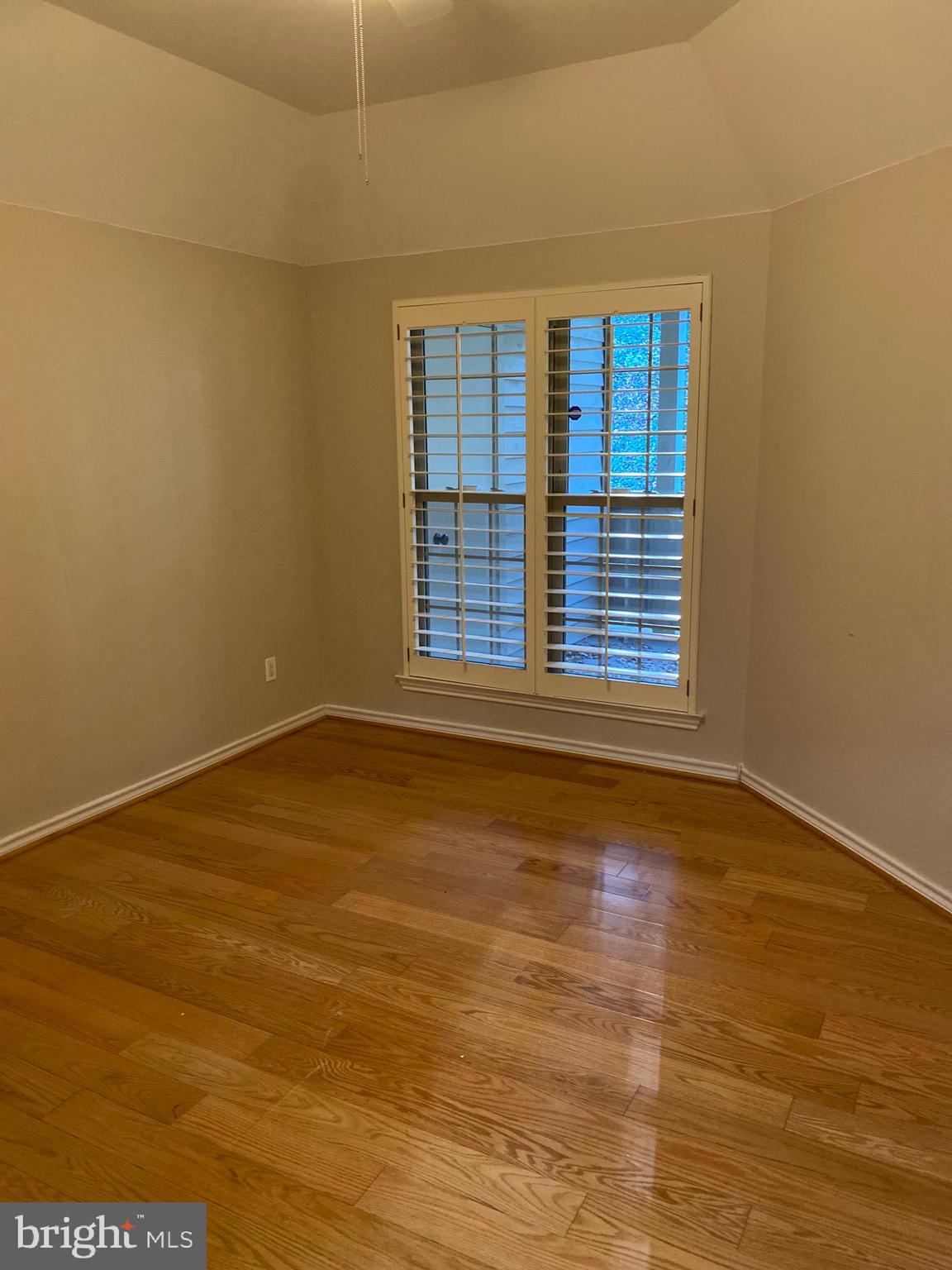 12161 Penderview Terrace, Unit 906 Fairfax, VA 22033 - Photo 10 of 20 a view of an empty room with wooden floor and a window