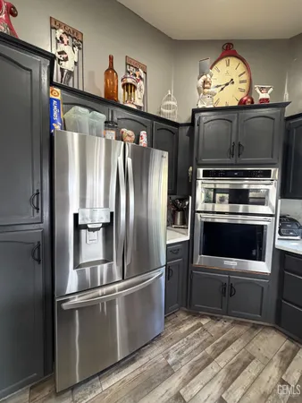 a large kitchen with a large counter top stainless steel appliances and cabinets
