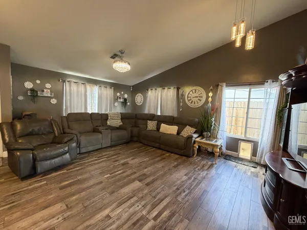 a living room with furniture flat screen tv and wooden floor