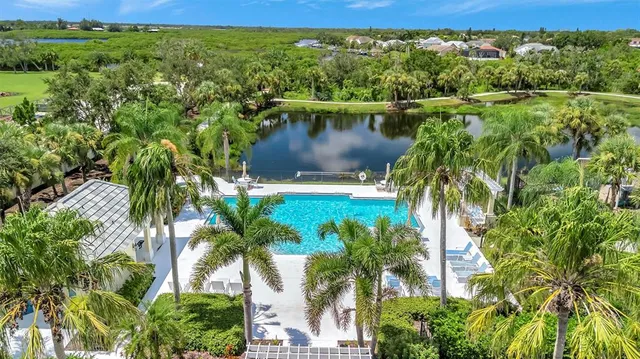 a view of a swimming pool with lawn chairs under an umbrella