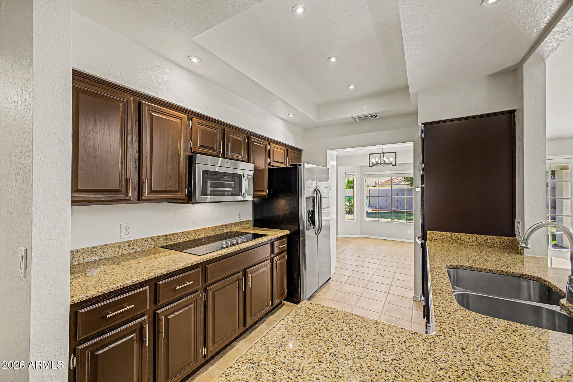 6725 West Utopia Road Glendale, AZ 85308 - Photo 10 of 27 a kitchen with stainless steel appliances granite countertop a refrigerator and a sink