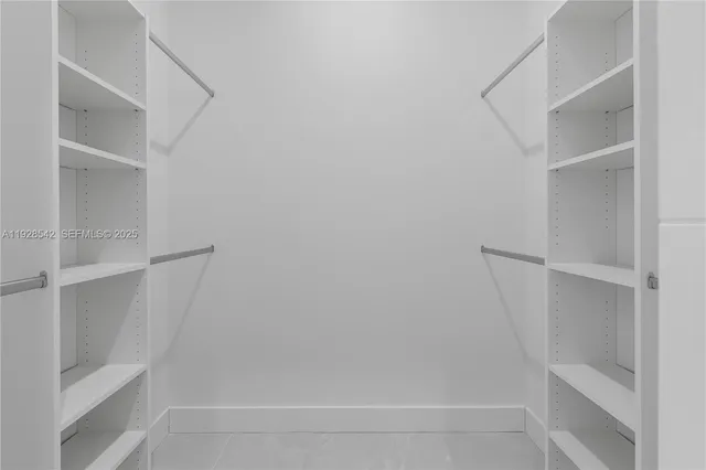 a view of walk in closet with empty racks