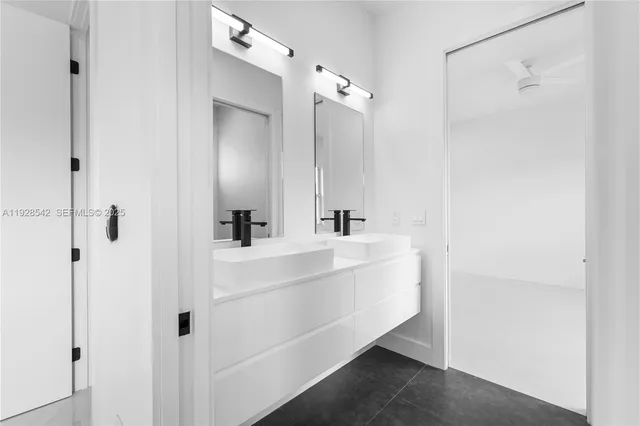 a bathroom with a bathtub shower sink vanity and mirror