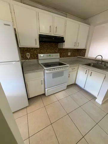 a kitchen with a stove a sink and a refrigerator
