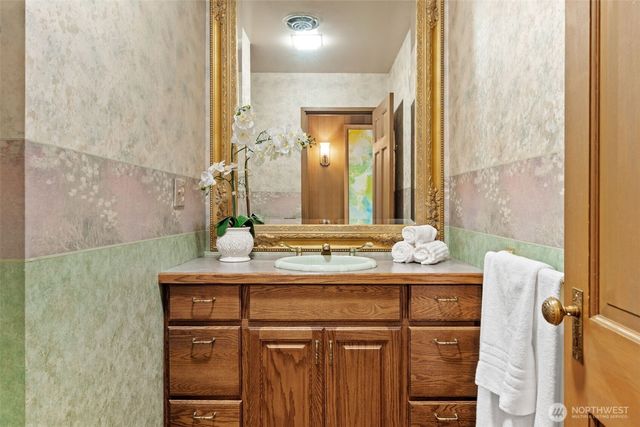 a bathroom with a granite countertop sink and a mirror