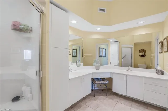 a large bathroom with a double vanity sink a large mirror and a shower