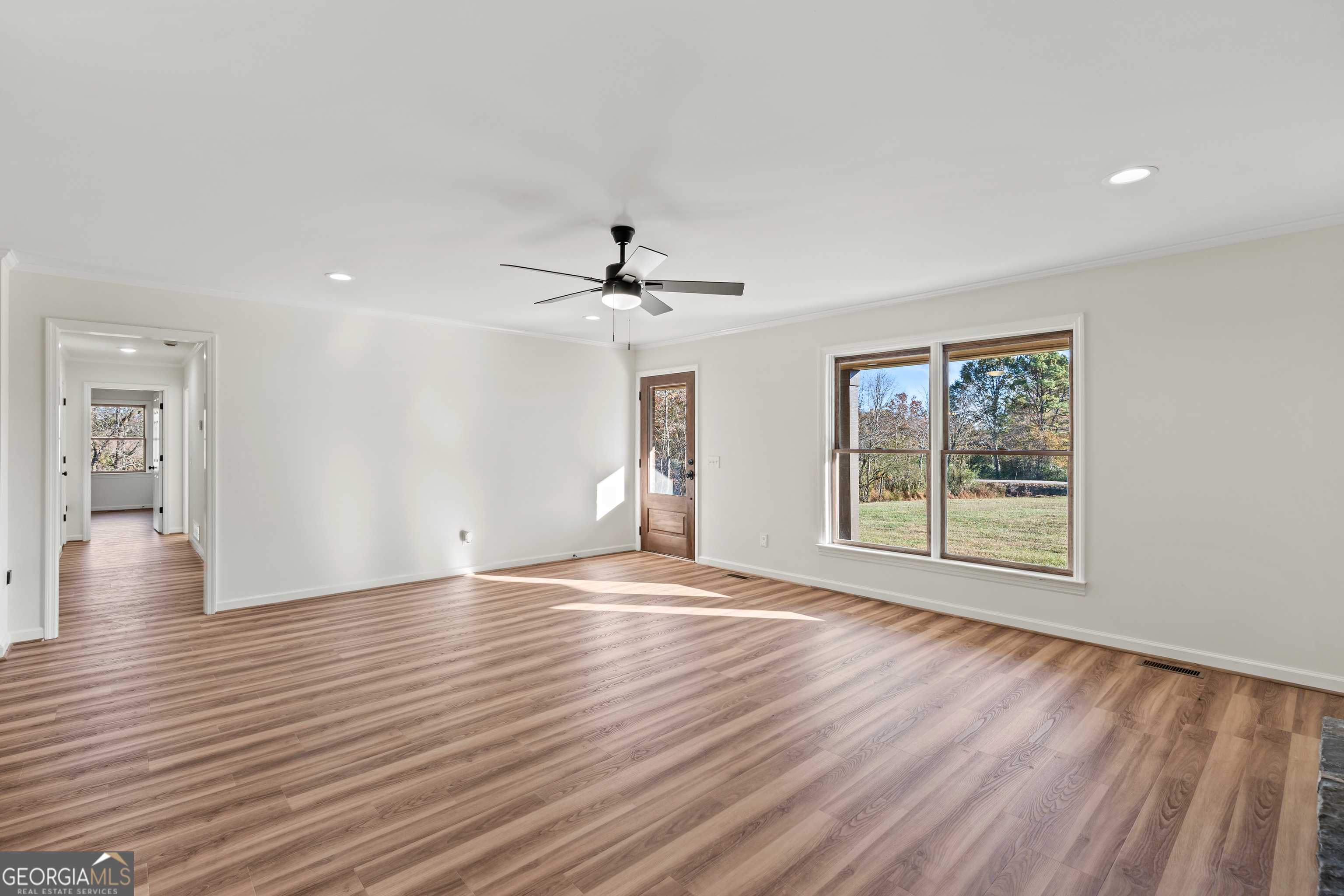 6421 Holly Springs Road Clermont, GA 30527 - Photo 16 of 58 a view of an empty room with wooden floor and a window