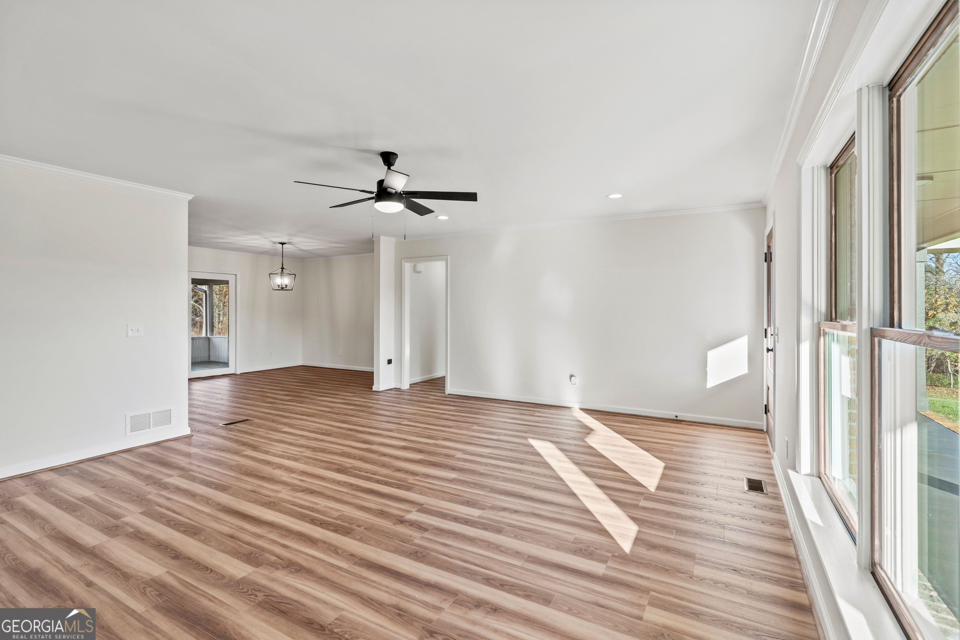 6421 Holly Springs Road Clermont, GA 30527 - Photo 17 of 58 a view of a livingroom with wooden floor and a ceiling fan
