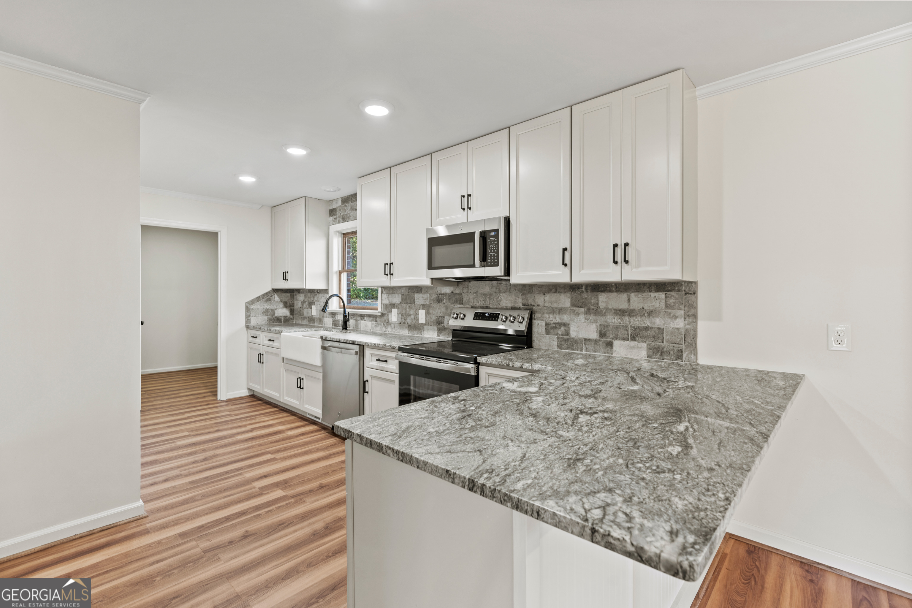 6421 Holly Springs Road Clermont, GA 30527 - Photo 19 of 58 a kitchen with stainless steel appliances granite countertop a sink stove and refrigerator