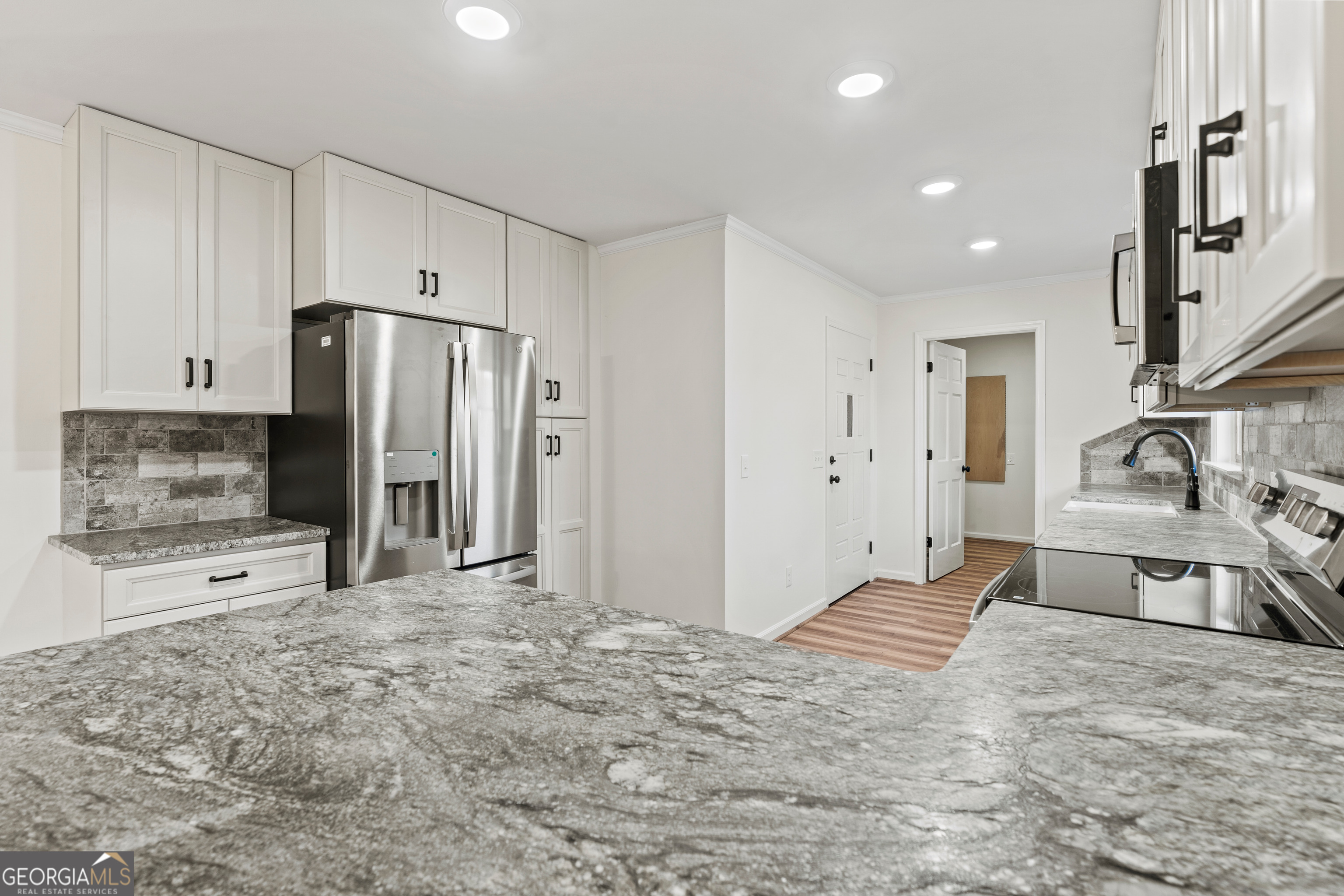 6421 Holly Springs Road Clermont, GA 30527 - Photo 20 of 58 a large kitchen with a refrigerator and a sink