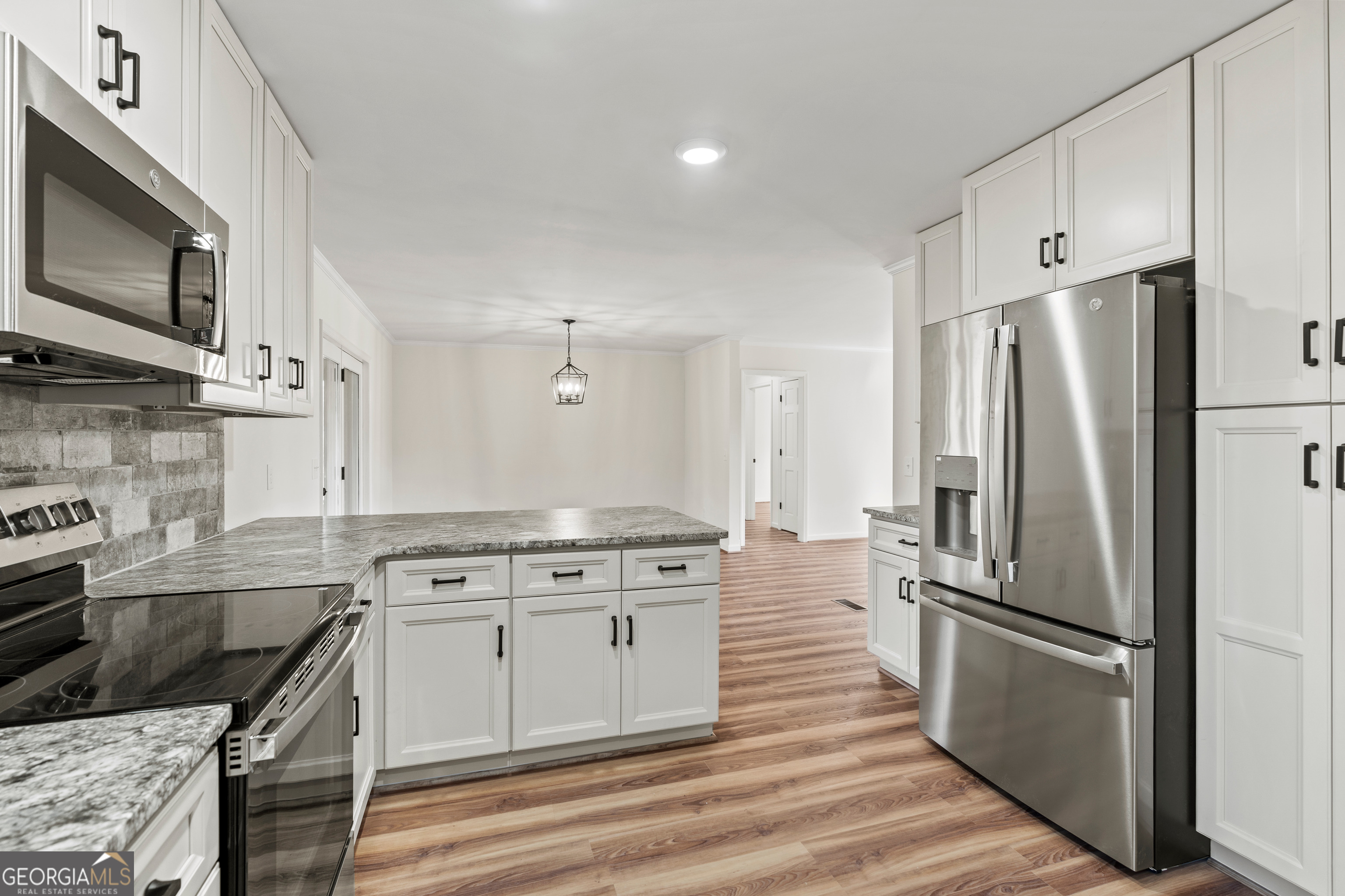 6421 Holly Springs Road Clermont, GA 30527 - Photo 22 of 58 a kitchen with stainless steel appliances granite countertop a stove a refrigerator and a microwave