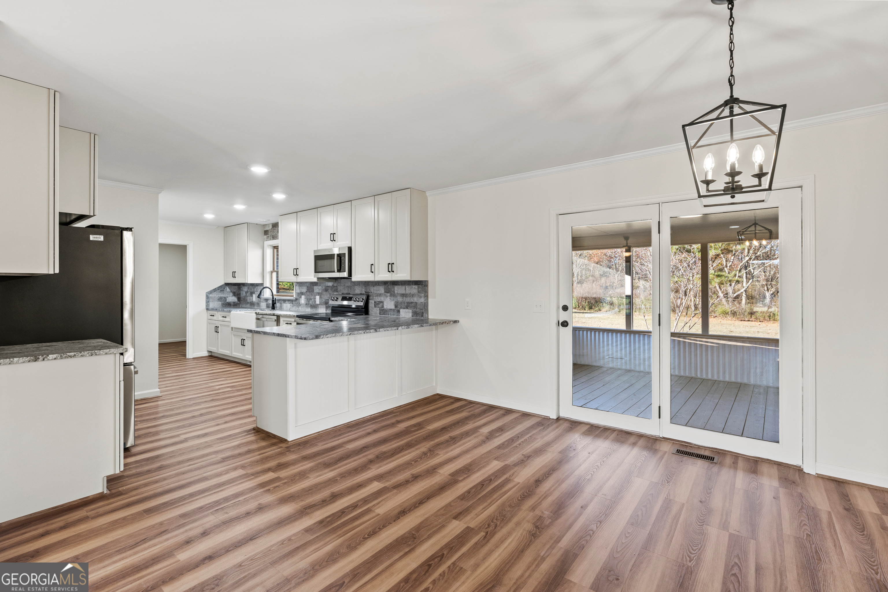 6421 Holly Springs Road Clermont, GA 30527 - Photo 25 of 58 a view of kitchen and empty room with wooden floor