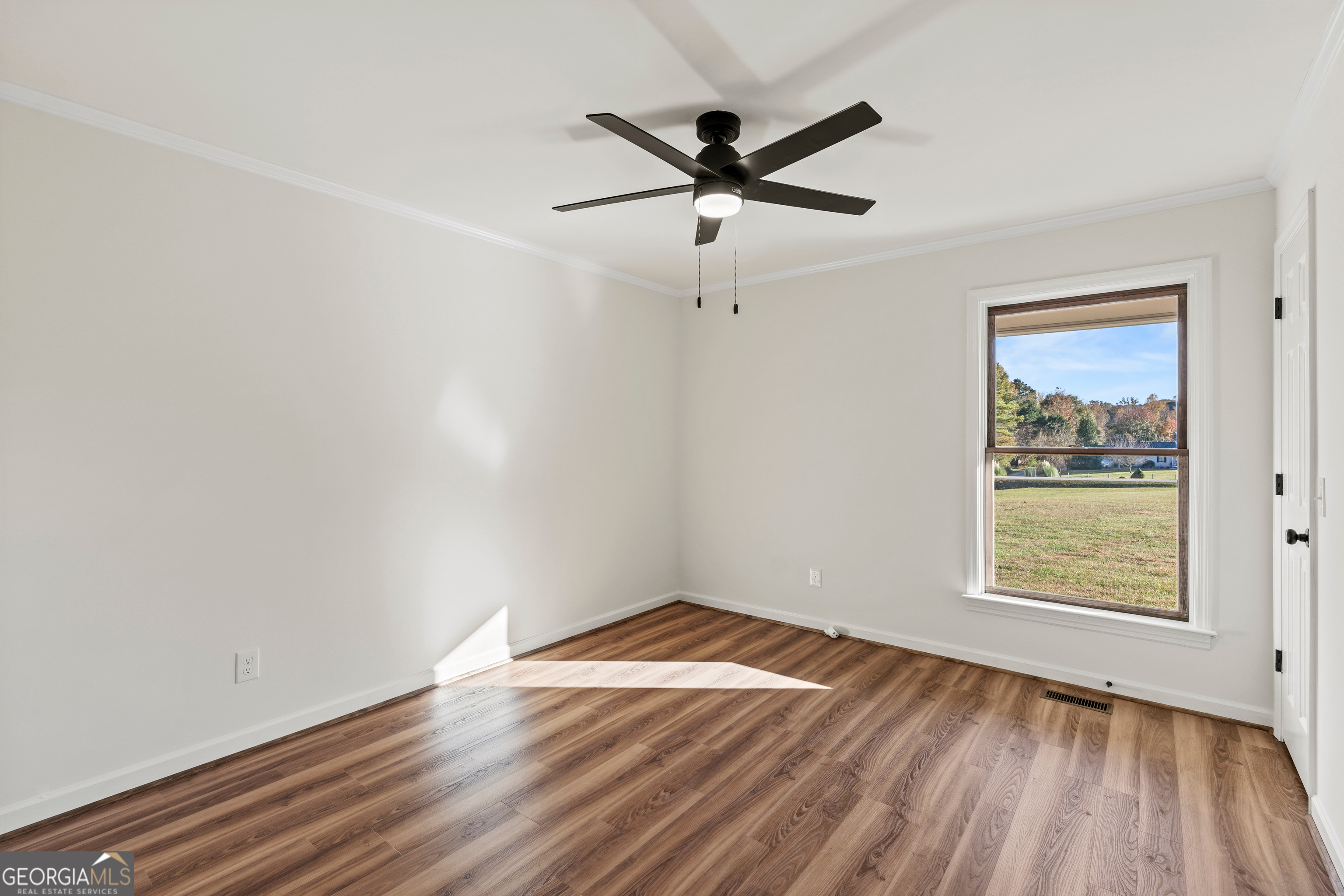 6421 Holly Springs Road Clermont, GA 30527 - Photo 36 of 58 a view of empty room with wooden floor and fan