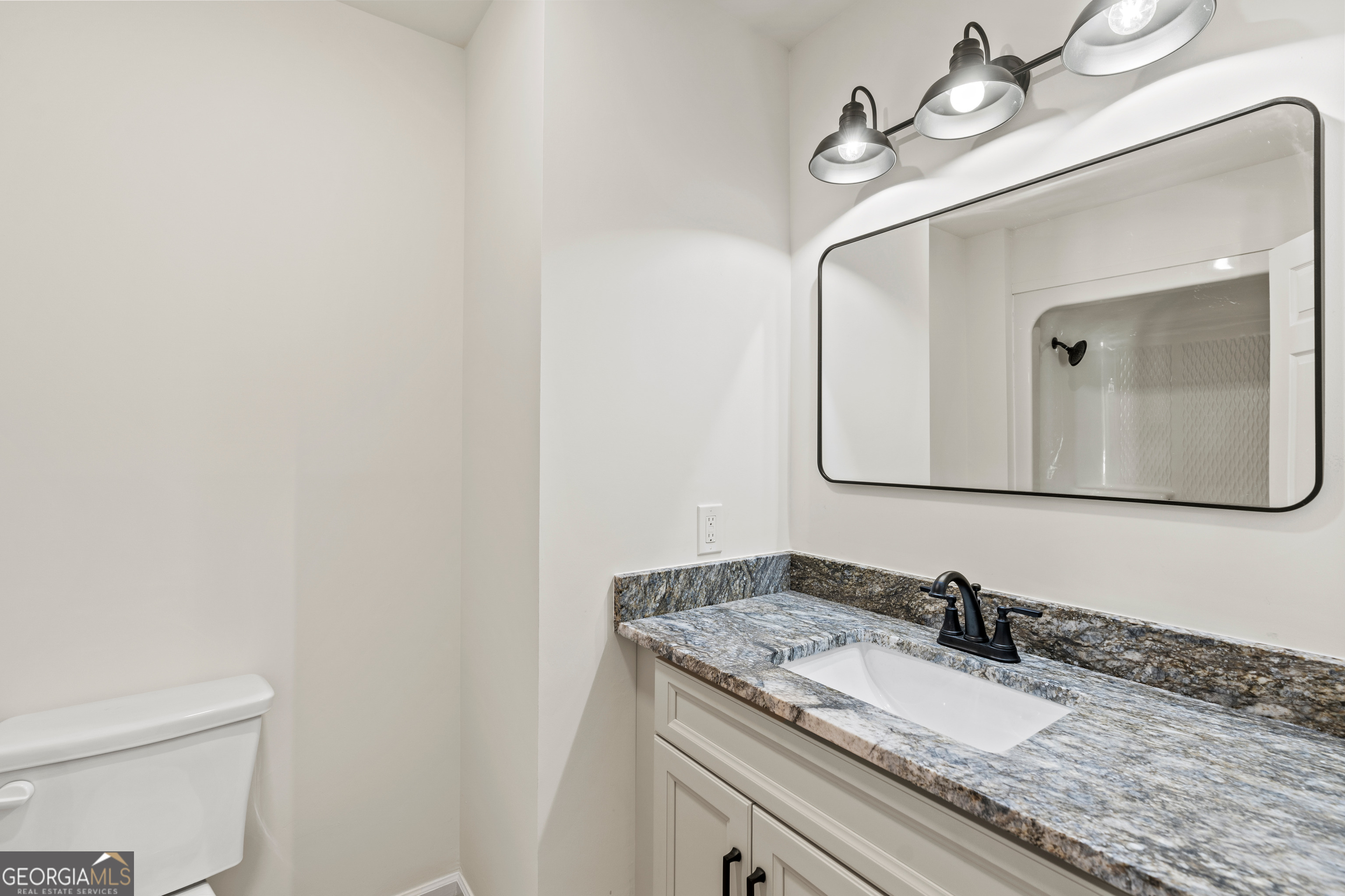 6421 Holly Springs Road Clermont, GA 30527 - Photo 37 of 58 a bathroom with a granite countertop sink and a mirror