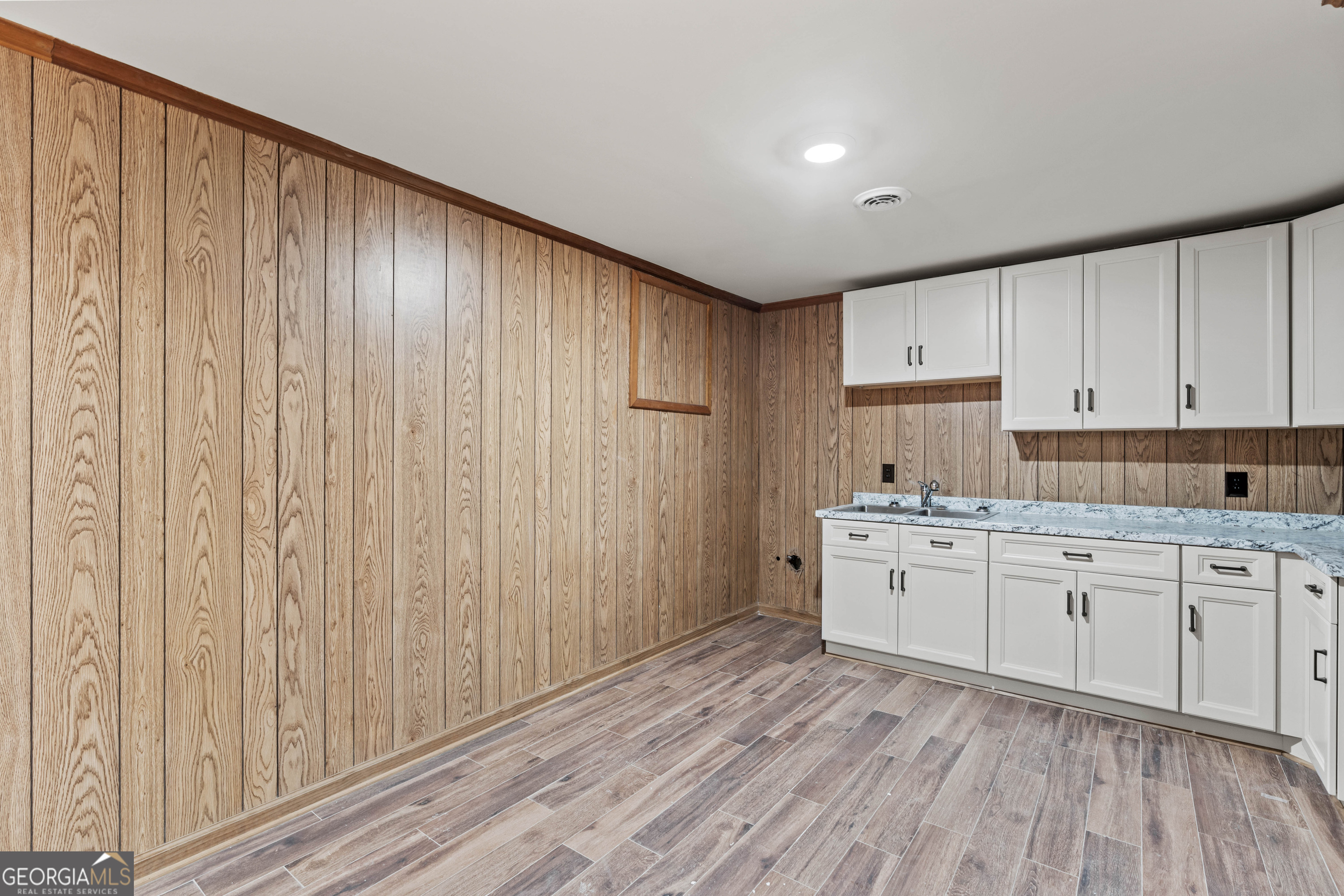 6421 Holly Springs Road Clermont, GA 30527 - Photo 42 of 58 a kitchen with granite countertop white cabinets a sink and dishwasher