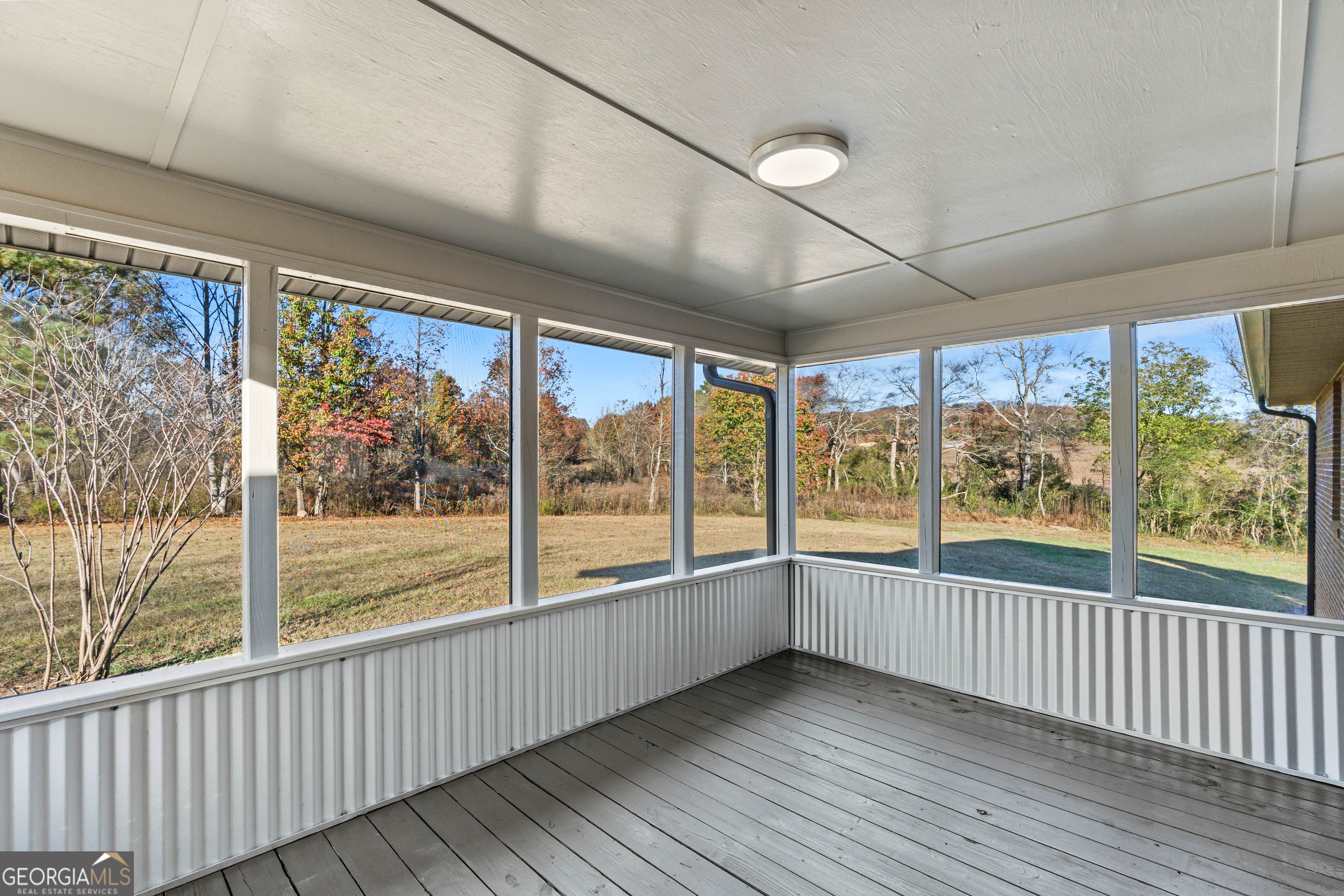 6421 Holly Springs Road Clermont, GA 30527 - Photo 51 of 58 a view of an empty room with wooden floor and large windows