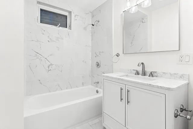 a bathroom with a tub sink and mirror