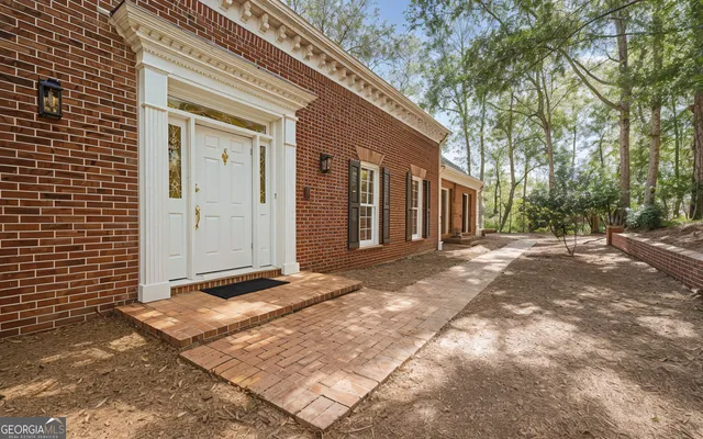 a view of a house with backyard and trees