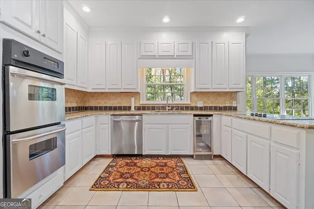 a kitchen with stainless steel appliances granite countertop a refrigerator and a sink