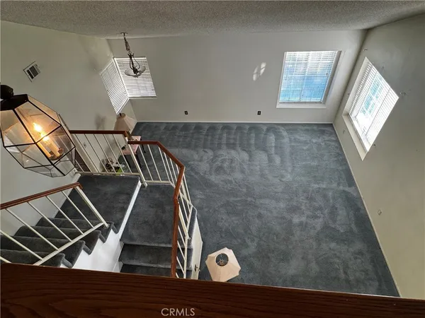 an empty room with wooden floor and stairs
