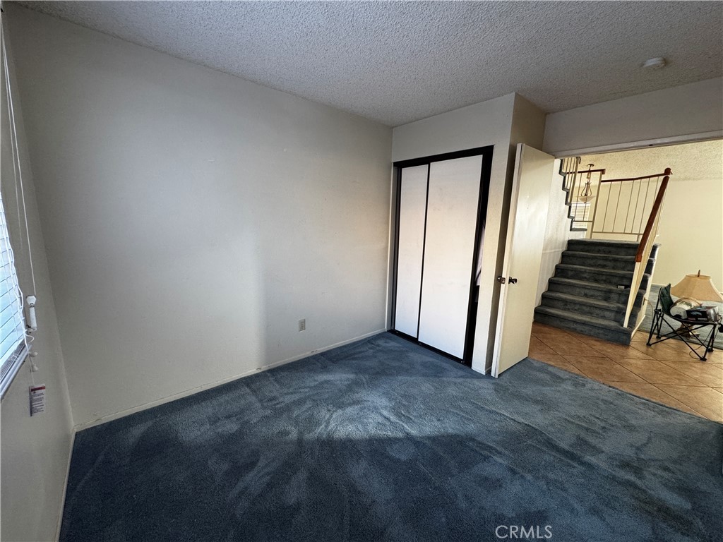 935 West Wabash Street Rialto, CA 92376 - Photo 9 of 17 an empty room with wooden floor and stairs