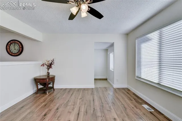 a view of a room with a large window and wooden floor