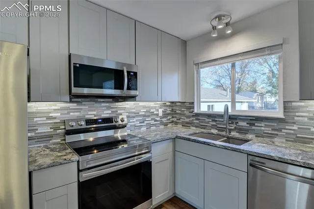 a kitchen with stainless steel appliances a stove sink microwave and cabinets