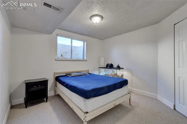 a bed sitting in a bedroom next to a window