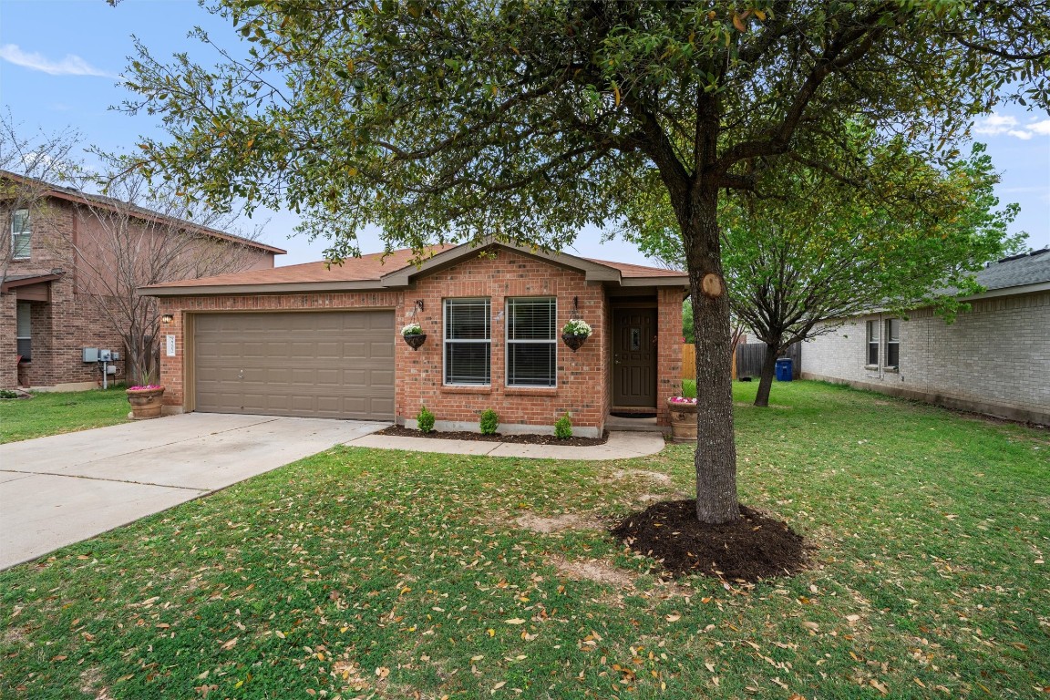 a front view of a house with a garden and trees