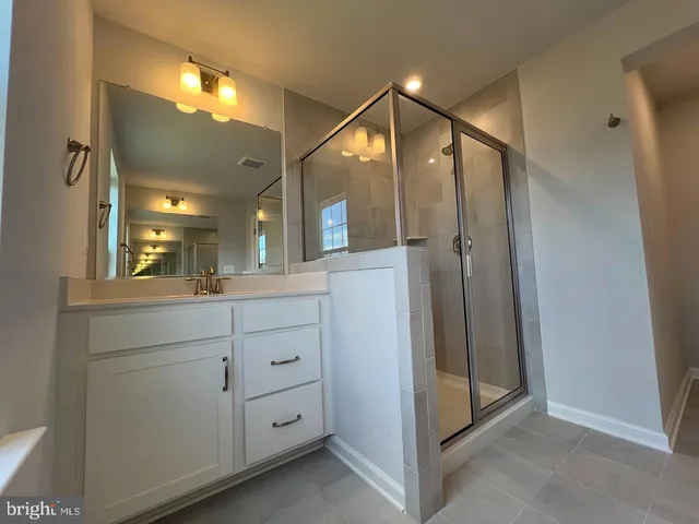a bathroom with a shower sink and mirror