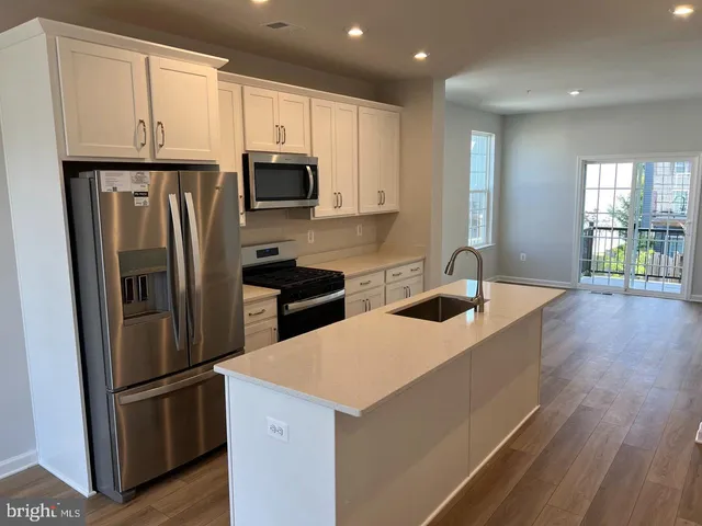 a kitchen with stainless steel appliances a refrigerator sink and microwave