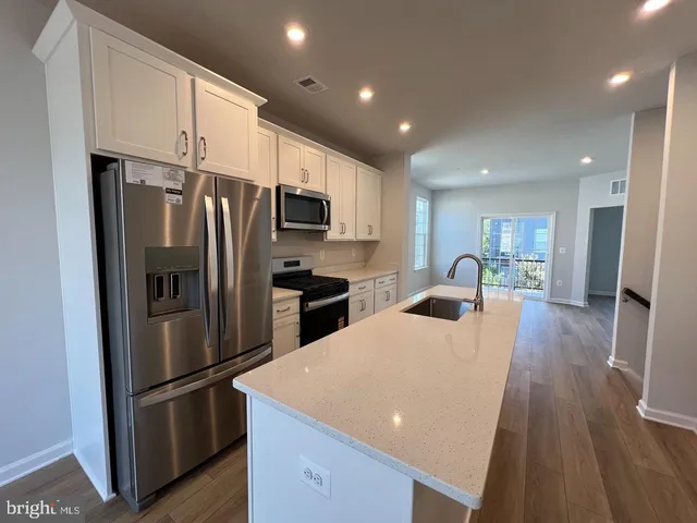 a kitchen with stainless steel appliances a refrigerator stove microwave and cabinets