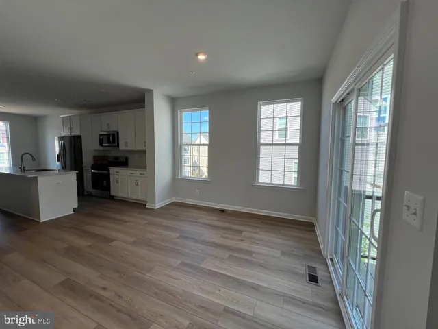 a view of a living room hardwood floor and a window