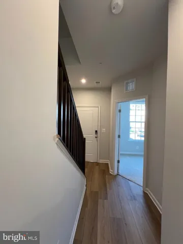 a view of hallway with stairs and wooden floor
