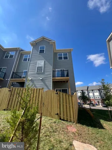 a view of a house with a wooden fence