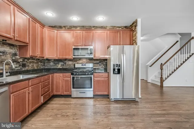a kitchen with stainless steel appliances granite countertop a refrigerator sink and cabinets