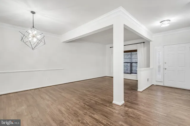 a view of a room with wooden floor staircase and a kitchen space