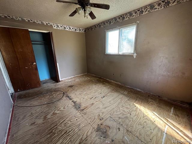 3901 West Lovejoy Road Byron, MI 48418 - Photo 10 of 19 Unfurnished bedroom with a textured ceiling, a closet, and ceiling fan
