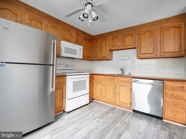 a kitchen with granite countertop white cabinets and white stainless steel appliances