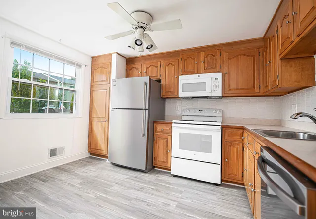 a kitchen with a refrigerator sink and cabinets
