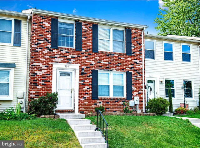 a view of a brick house with a yard and plants