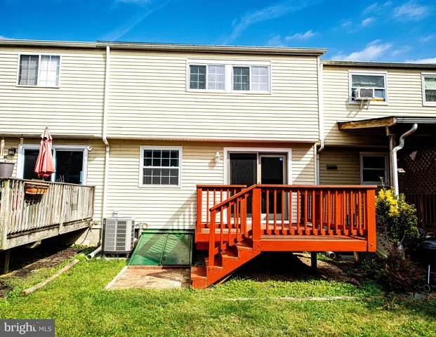 a view of a house with a wooden deck and a yard