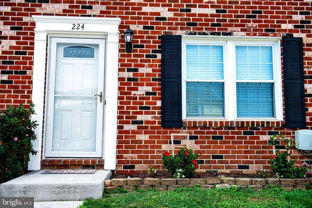 a view of a brick house with a yard and plants