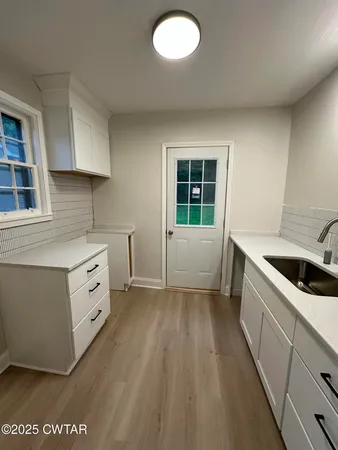 a kitchen with granite countertop a sink stove and cabinets
