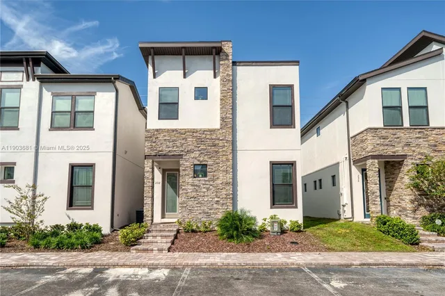 a front view of a house with yard and parking