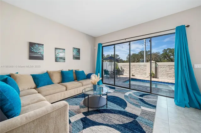 a living room with furniture and a floor to ceiling window